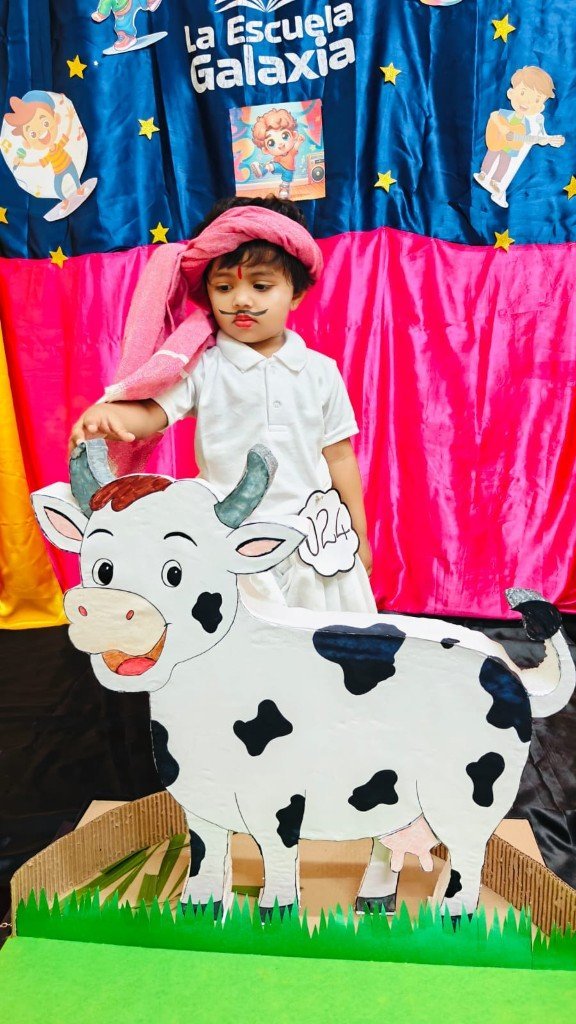 Child with cow costume prop at a La Escuela Galaxia celebration