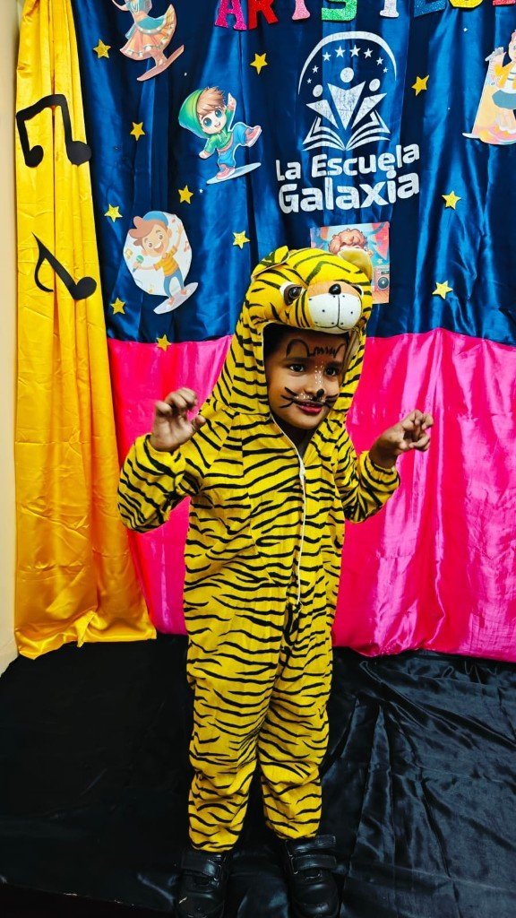 Child in tiger costume posing on stage at La Escuela Galaxia