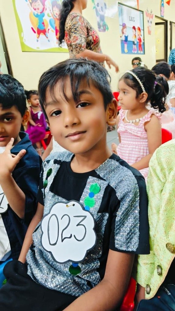 Grade 1 boy in sequin costume with Arts Fest number tag