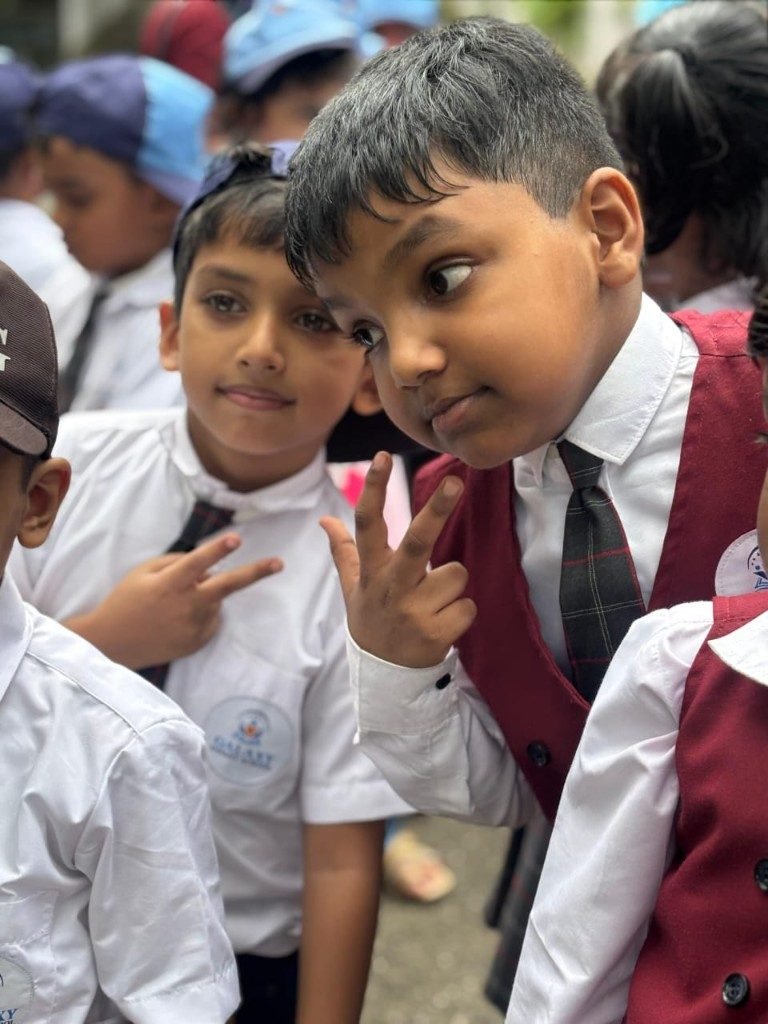 Grade 1 boys in Galaxy uniforms smiling and making peace signs