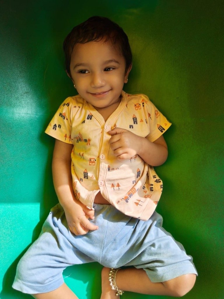 Happy infant smiling while playing in a soft play tunnel at La Escuela Galaxia