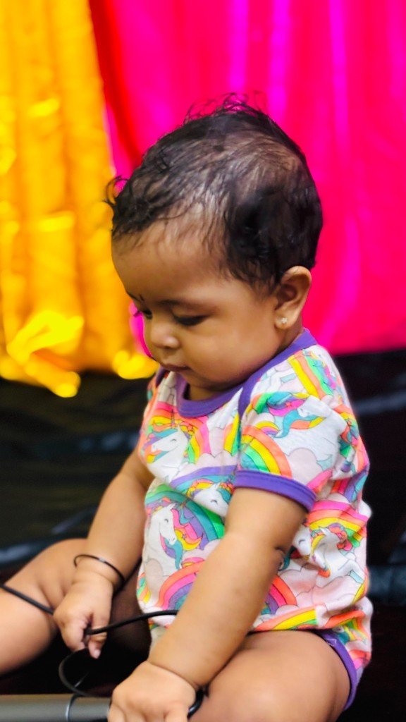 Infant in rainbow unicorn onesie during Infant Care at La Escuela Galaxia