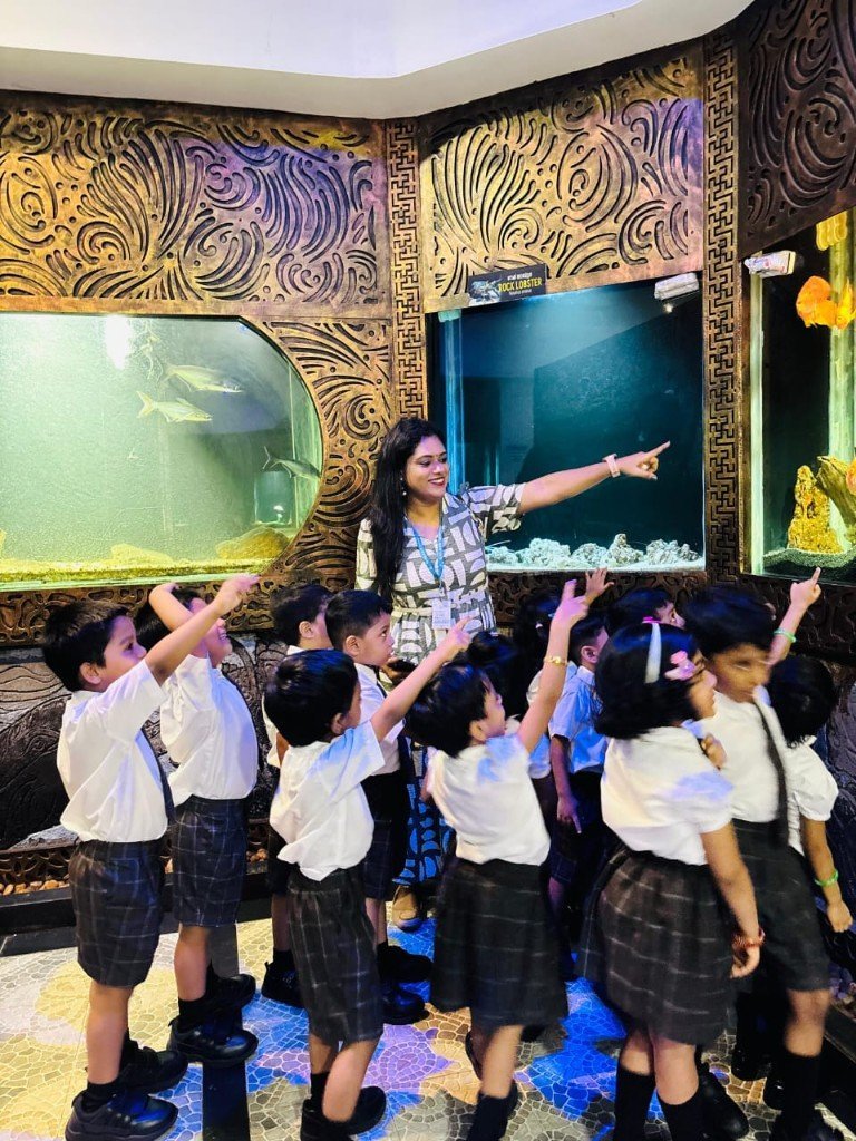 Teacher and Galaxy Infant School students exploring an aquarium on a hands-on learning visit