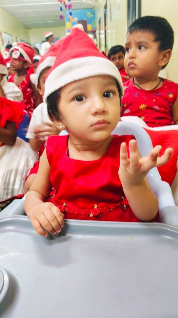 Toddler in Santa hat at festive classroom event